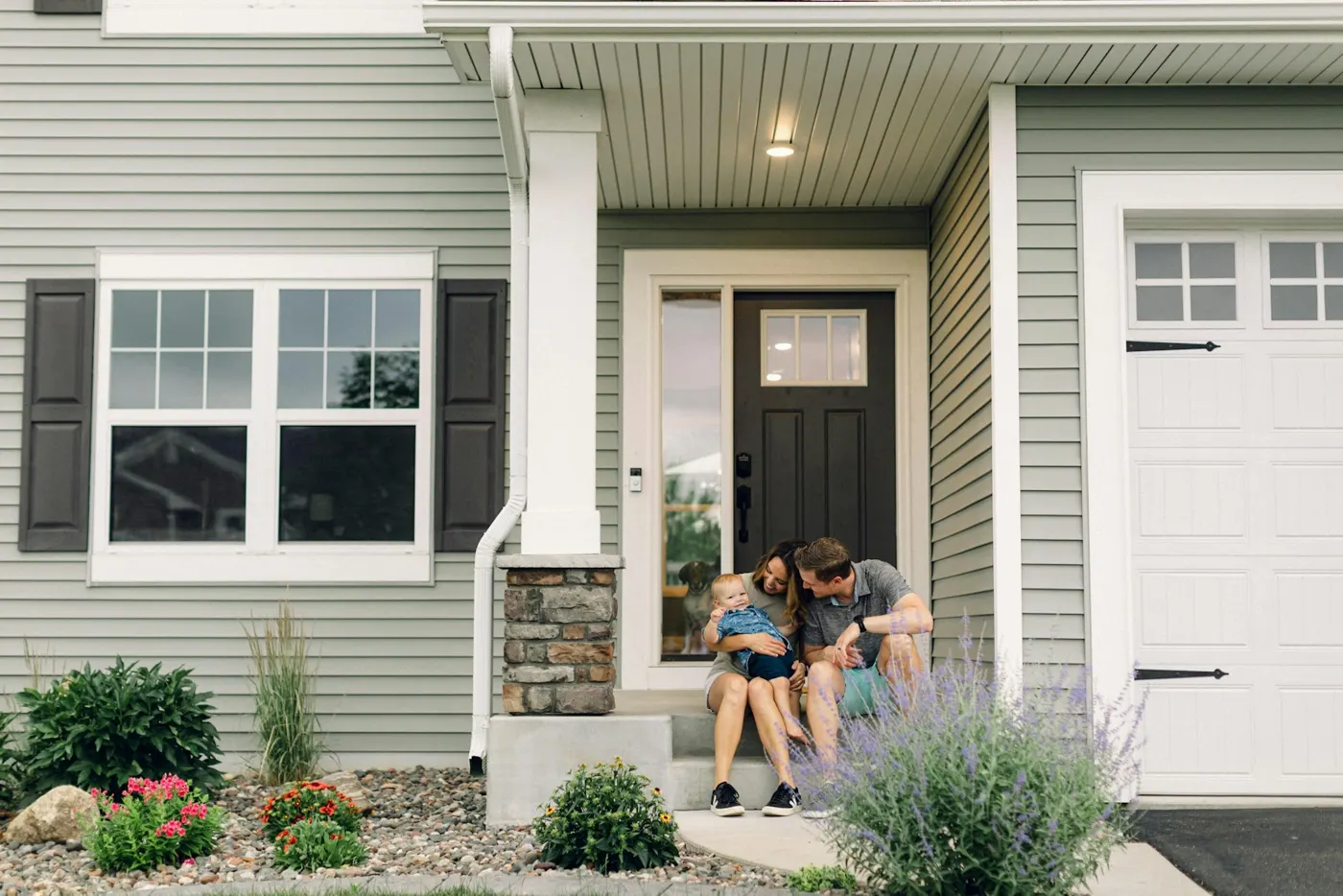 A couple sitting on the front steps of a house