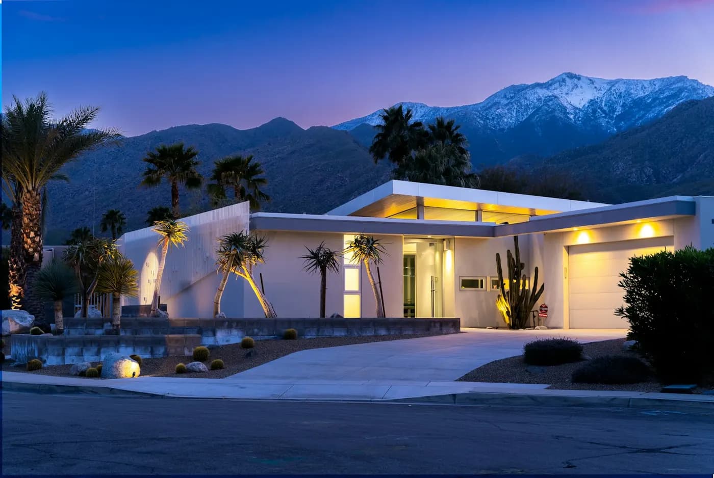 A Southern California home at dusk, its windows lit warm against the mountains